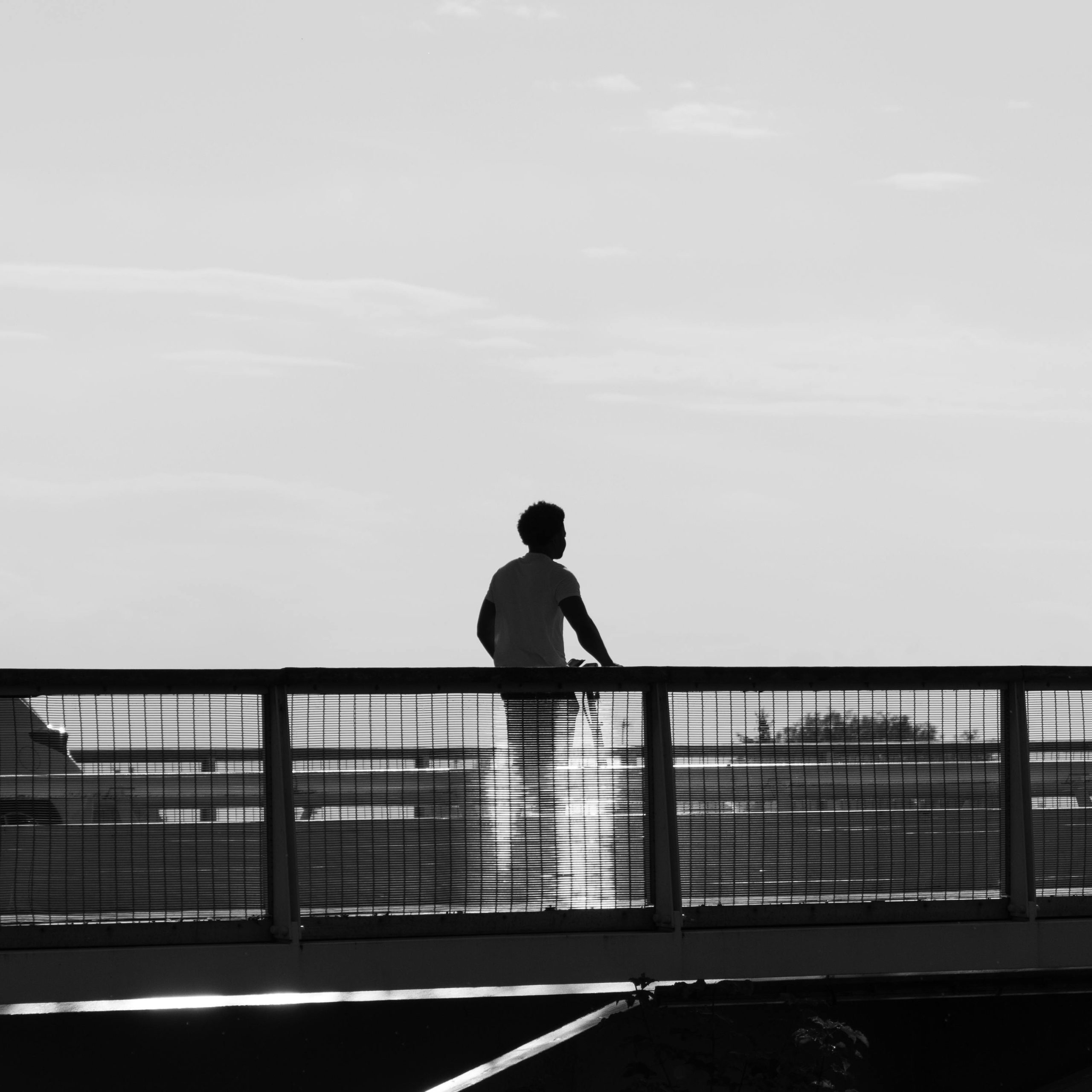 Black and white silhouette of a man standing on a bridge in Compiègne, Upper France.